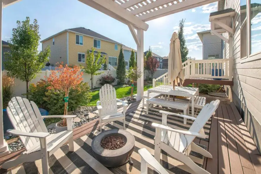 A sunny backyard Trex deck with safe seating and a fire pit.