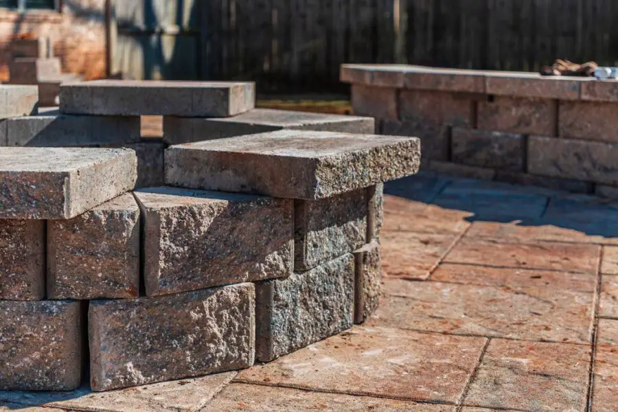 Pile of interlocking paving stones at a construction site, questioning if fire pits will damage pavers.