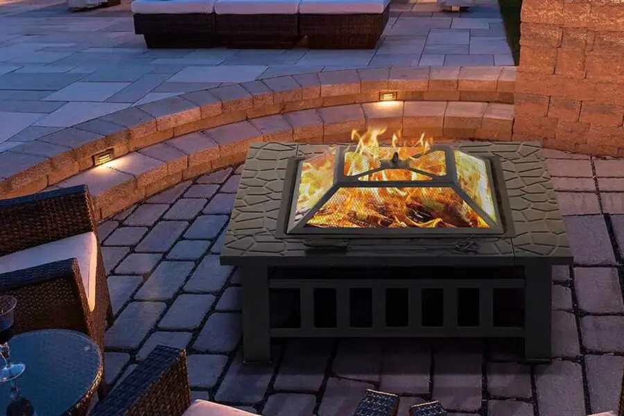An outdoor patio with a lit fire pit in use and seating arrangement at dusk.