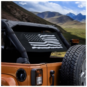 An orange jeep with an american flag decal on the rear window driving through a mountainous landscape.