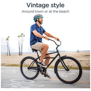 Man riding a retro bicycle on a beachside path, sporting casual attire and a helmet.